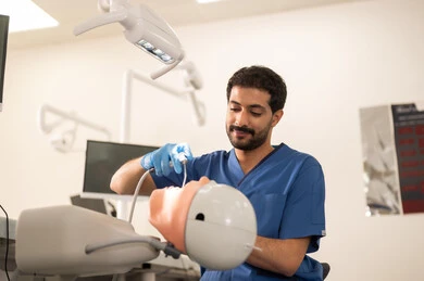 تنظيف الأسنان من النخر، طالب جامعي بكلية الأسنان يرتدي القفازات يقوم بفحص مجسم به طاقم أسنان، مفهوم التدريب العملي، المعدات والادوات اللازمة لإجراء الفحوصات, الأساليب العلاجية المتبعة للعناية بالفم