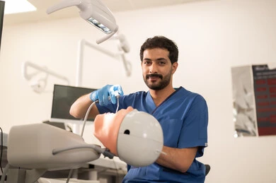 إصلاح الأسنان المتضررة بالتسوس، طالب جامعي بكلية الأسنان يرتدي القفازات يقوم بفحص مجسم به طاقم أسنان، مفهوم التدريب العملي، المعدات والادوات اللازمة لإجراء الفحوصات, الأساليب العلاجية المتبعة للعناية بالفم