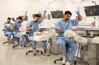 استخدام المعدات الطبية الخاصة بالفم، طرق علاجية للعناية بالأسنان، معالجة التسوس وتركيب الحشوات، مجموعة من الطلاب الجامعيين بكلية الأسنان يرتدون القفازات يقومون بفحص الأسنان على مجسم