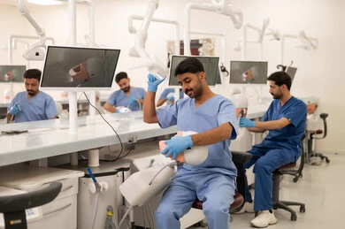 توظيف الأجهزة السنية خلال العلاج، طرق علاجية للعناية بالأسنان، معالجة التسوس وتركيب الحشوات، مجموعة من الطلاب الجامعيين بكلية الأسنان يرتدون القفازات يقومون بفحص الأسنان على مجسم