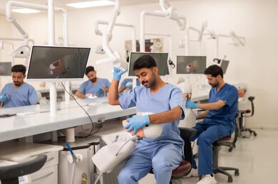 استخدام أدوات التشخيص في طب الأسنان، طرق علاجية للعناية بالأسنان، معالجة التسوس وتركيب الحشوات، مجموعة من الطلاب الجامعيين بكلية الأسنان يرتدون القفازات يقومون بفحص الأسنان على مجسم