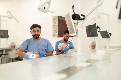 تطبيق معدات طب الأسنان ، طرق علاجية للعناية بالأسنان، معالجة التسوس وتركيب الحشوات، مجموعة من الطلاب الجامعيين بكلية الأسنان يرتدون القفازات يقومون بفحص الأسنان على مجسم