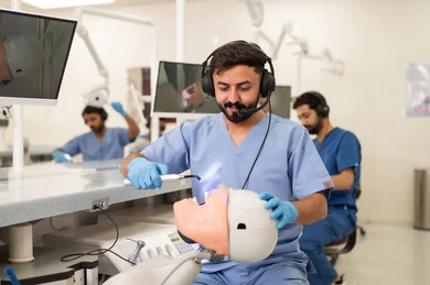 The use of clinical tools for dental treatment, therapeutic methods for dental care, treatment of cavities and placement of fillings, a group of university students from the dental college wearing gloves examining teeth on a model.
