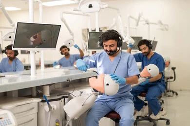 The use of dental devices during treatment, therapeutic methods for dental care, treating cavities and placing fillings, a group of university students in the dental college wearing gloves examining teeth on a model.