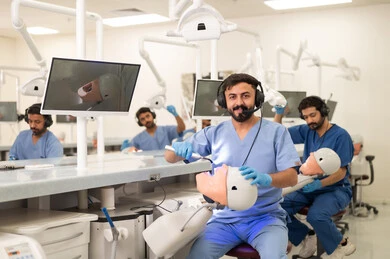 Use of dental medical equipment, therapeutic methods for dental care, treatment of cavities and placement of fillings, a group of university students in the dental college wearing gloves examining teeth on a model.