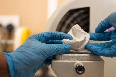 استخدام معدات التشخيص والعلاج في طب الأسنان ، مفهوم التدريب العملي، معالجة التسوس وتركيب الحشوات، صورة مقربة ليد طالب جامعي بكلية الأسنان يرتدي القفازات يقوم تحضير المواد الطبية للحشوات