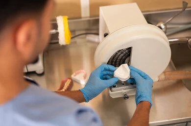Operating devices and tools dedicated to dental treatment, the concept of practical training, treating cavities and placing fillings, a close-up image of a dental student wearing gloves preparing medical materials for dental fillings.