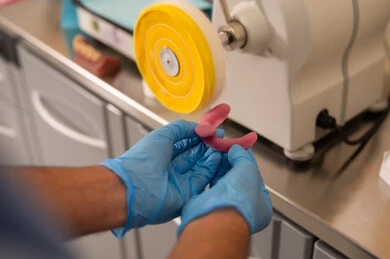 تشغيل الأدوات والمعدات السنية في الإجراءات العلاجية، مفهوم التدريب العملي،  معالجة التسوس وتركيب الحشوات، صورة مقربة ليد طالب جامعي بكلية الأسنان يرتدي القفازات يقوم تحضير المواد الطبية لحشوات الأسنان