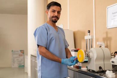 الاستعانة بمعدات وأدوات علاج الأسنان، مفهوم التدريب العملي، الأساليب العلاجية المتبعة للعناية بالفم، معالجة التسوس وتركيب الحشوات، طالب جامعي بكلية الأسنان يرتدي القفازات يقوم تحضير المواد الطبية لحشوات الأسنان