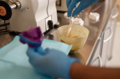 استعمال أدوات ومعدات طب الأسنان، مفهوم التدريب العملي، الأساليب العلاجية المتبعة للعناية بالفم، معالجة التسوس وتركيب الحشوات، صورة مقربة ليد طالب جامعي بكلية الأسنان يرتدي القفازات يقوم تحضير المواد الطبية لحشوات الأسنان