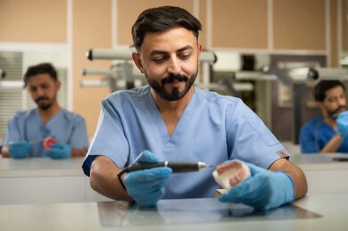 معالجة تلف الأسنان الناتج عن التسوس وتركيب الحشوات المناسبة، مجموعة من الطلاب الجامعيين بكلية الأسنان يرتدون القفازات يقومون بفحص مجسم طاقم أسنان، استخدام معدات وأدوات طب الأسنان، الأساليب العلاجية المتبعة للعناية بالفم