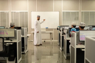 تركيز وانسجام الطلاب أثناء الاستماع إلى المحاضرة، تطوير أساليب التعليم الجامعي في سلطنه عمان، معلم عربي خليجي عماني يرتدي الدشداشة و الكمة يقوم بشرح المحاضرة للطلاب، ورش عمل ودورات تدريبية، التعليم الجامعي العماني