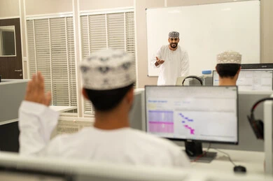 رفع اليدين للتفاعل والمشاركه، أستاذ جامعي عربي خليجي عماني يرتدي الدشداشة و الكمة يشرح لطلابه في المحاضره, الإستماع الى المحاضره, جامعات أكاديميه في سلطنه عمان , كليات وجامعات متطوره