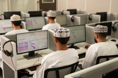 التعليم التكنولوجي داخل الجامعة، الانجاز و التفوق في المرحلة الجامعية، صورة من الخلف لمجموعه من الطلاب العربيون الخليجيون العمانيون يرتدون الدشداشة و الكمة يجلسون امام الحاسوب، جامعات أكاديميه في سلطنه عمان