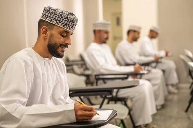 تعابير تدل على التفكير العميق والتركيز، التعليم في سلطنه عمان، الاجتهاد في الدراسة لتحقيق النجاح والتميز الأكاديمي, اهداف التربية و التعليم، مجموعه من الطلاب العرب الخليجيون العمانيون يرتدون الدشداشة و الكمة يقومون بحل اسئله الامتحان