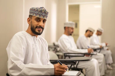 End of the semester, gestures of thinking and focus on exam questions, a group of Arab Gulf Omani students wearing the dishdasha and kumma are solving the exam, education in the Sultanate of Oman, goals of education and teaching.