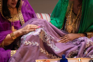 ارتداء الحلي والمجوهرات الذهبية، احتفالات سعيدة ومناسبات وأفراح، الاهتمام والعناية بالأناقة والجمال، منتجات ومساحيق التجميل، صورة مقربة لسيداتان عربيتان خليجيتان اماراتيتان يقومون بعرض الفساتين والمجوهرات احداهن ترتدي البرقع، إيماءات السعادة والفرح ، الاحتفال بليلة العمر