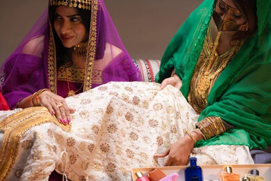 An Emirati woman wearing a burqa, happy celebrations, occasions, and festivities, attention and care for elegance and beauty, beauty products and cosmetics, a close-up image of two Arab Gulf Emirati women showcasing dresses and jewelry, gestures of happiness and joy, celebrating the night of a lifetime.