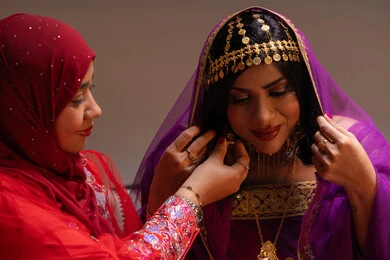 تعطير العروس بعطور ذات روائح مميزة، احتفالات سعيدة ومناسبات وأفراح، الاهتمام والعناية بالأناقة والجمال، منتجات ومساحيق التجميل، صورة مقربة لسيداتان عربيتان خليجيتان اماراتيتان يقومون بعرض الفساتين والمجوهرات، إيماءات السعادة والفرح ، الاحتفال بليلة العمر