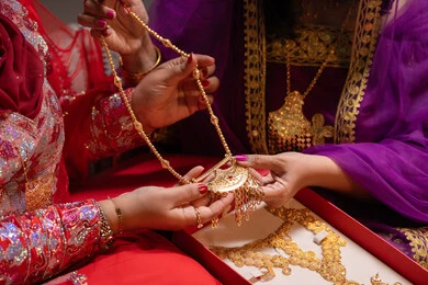 تقديم الصيغة الذهبية كهدية زفاف، احتفالات سعيدة ومناسبات وأفراح، الاهتمام والعناية بالأناقة والجمال، منتجات ومساحيق التجميل، صورة مقربة لسيداتان عربيتان خليجيتان اماراتيتان يقومون باستعراض التحضيرات والتجهيزات للزفاف، إيماءات السعادة والفرح ، الاحتفال بليلة العمر