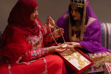 جمال الصيغة الذهبية في الزفاف، احتفالات سعيدة ومناسبات وأفراح، الاهتمام والعناية بالأناقة، منتجات ومساحيق التجميل، صورة مقربة لسيداتان عربيتان خليجيتان اماراتيتان يقومون باستعراض التحضيرات والتجهيزات للزفاف، إيماءات السعادة والفرح ، الاحتفال بليلة العمر