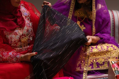 شال من القماش الاسود شفاف فاخر، العادات والتقاليد في التقدم لطلب يد الفتاة، احتفالات سعيدة ومناسبات وأفراح،  منتجات ومساحيق التجميل، صورة مقربة لسيداتان عربيتان خليجيتان اماراتيتان يقومون باستعراض التحضيرات والتجهيزات للزفاف، إيماءات السعادة والفرح ، الاحتفال بليلة العمر