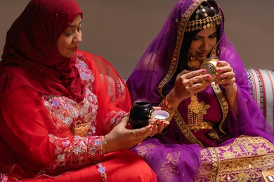 التطيب والتعطر بالروائح العربية، العادات والتقاليد في التقدم لطلب يد الفتاة، احتفالات سعيدة ومناسبات، منتجات ومساحيق التجميل، صورة مقربة لسيداتان عربيتان خليجيتان اماراتيتان يقومون باستعراض التحضيرات والتجهيزات للزفاف، إيماءات السعادة والفرح، الاحتفال بليلة العمر