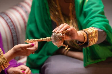 The use of a sprayer to spray rose water, beauty products and powders, customs and traditions in proposing to a girl, happy celebrations and occasions, a close-up image of two Emirati Gulf Arab women showcasing the preparations and arrangements for the wedding, gestures of happiness and joy, celebrating the night of a lifetime.