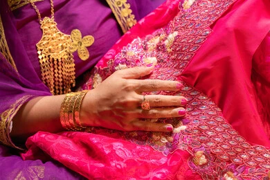 ثوب تقليدي بلون ربيعي، منتجات ومساحيق التجميل، التقاليد في التقدم لطلب يد الفتاة، احتفالات سعيدة ومناسبات، صورة مقربة لسيدة عربية خليجية اماراتية تقوم باستعراض التحضيرات والتجهيزات للزفاف ترتدي الملابس التقليدية، إيماءات السعادة والفرح، الاحتفال بليلة العمر