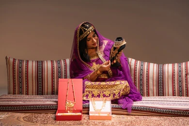 استخدام الذوق الرفيع في اختيار الحلي ، منتجات ومساحيق التجميل، التقاليد في التقدم لطلب يد الفتاة، احتفالات سعيدة ومناسبات، صورة مقربة لسيدة عربية خليجية اماراتية تقوم باستعراض التحضيرات والتجهيزات للزفاف ترتدي الملابس التقليدية، الاحتفال بليلة العمر