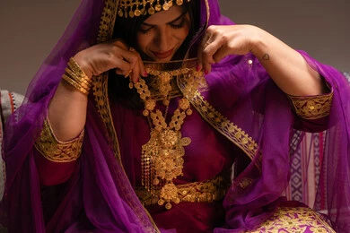 تجريب الحلي وارتدائه قبل الزفاف ، منتجات ومساحيق التجميل، التقاليد في التقدم لطلب يد الفتاة، احتفالات سعيدة ومناسبات، صورة مقربة لسيدة عربية خليجية اماراتية تقوم باستعراض التحضيرات والتجهيزات للزفاف ترتدي الملابس التقليدية، إيماءات السعادة والفرح، الاحتفال بليلة العمر