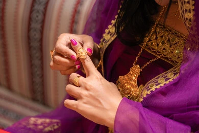 استبدال خواتم الزواج، منتجات ومساحيق التجميل، التقاليد في التقدم لطلب يد الفتاة، احتفالات سعيدة ومناسبات، صورة مقربة لسيدة عربية خليجية اماراتية تقوم باستعراض التحضيرات والتجهيزات للزفاف ترتدي الملابس التقليدية، إيماءات السعادة والفرح، الاحتفال بليلة العمر