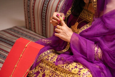 صناعة الحلي والذهب خاتم زواج فاخر، منتجات ومساحيق التجميل، التقاليد في التقدم لطلب يد الفتاة، احتفالات سعيدة ومناسبات، صورة مقربة لسيدة عربية خليجية اماراتية تقوم باستعراض التحضيرات والتجهيزات للزفاف ترتدي الملابس التقليدية، إيماءات السعادة والفرح، الاحتفال بليلة العمر