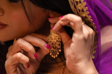 مفهوم التزين والاطلالة المتألقة، منتجات ومساحيق التجميل، التقاليد في التقدم لطلب يد الفتاة، احتفالات سعيدة ومناسبات، صورة مقربة لسيدة عربية خليجية اماراتية تقوم باستعراض التحضيرات والتجهيزات للزفاف ترتدي الملابس التقليدية، إيماءات السعادة والفرح، الاحتفال بليلة العمر