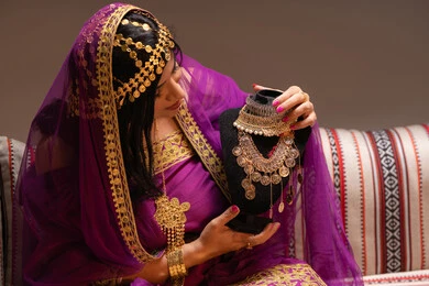 المجوهرات والحلي النسائية الفاخرة، منتجات ومساحيق التجميل، التقاليد في التقدم لطلب يد الفتاة، احتفالات سعيدة ومناسبات، صورة مقربة لسيدة عربية خليجية اماراتية تقوم باستعراض التحضيرات والتجهيزات للزفاف ترتدي الملابس التقليدية، إيماءات الفرح، الاحتفال بليلة العمر