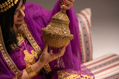 التطيب بالبخور والعود ، الاحتفال بليلة العمر، استعراض التحضيرات والتجهيزات للزفاف، التزين والاطلالة المتألقة، الأفراح والمناسبات السعيدة، مراسم الأعراس والاحتفالات،صورة  مقربة لعروس عربية خليجية اماراتية ترتدي الزي التقليدي الشعبي تمسك بيدها مبخرة تقليدية ذهبية