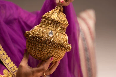 التطيب بالبخور والعود ، الاحتفال بليلة العمر، استعراض التحضيرات والتجهيزات للزفاف، التزين والاطلالة المتألقة، الأفراح والمناسبات السعيدة، مراسم الأعراس والاحتفالات،صورة  مقربة لعروس عربية خليجية اماراتية ترتدي الزي التقليدي الشعبي تمسك بيدها مبخرة تقليدية ذهبية