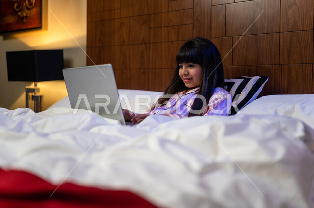 A Saudi Gulf Arab girl, having a video chat using a laptop computer, social communication and chatting, using modern technologies