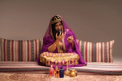 مستحضرات عطرية في حفل زفاف، مفهوم التزيين والإطلالة المتألقة، التزين بالحلي و المجوهرات الذهبية ، استخدام مساحيق التجميل لإبراز الجمال، عروس عربية خليجية اماراتية ترتدي الزي التقليدي الشعبي تقوم باستعراض التحضيرات والتجهيزات للزفاف، الاستعداد للاحتفال بليلة العمر