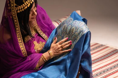 التزين بالحلي و المجوهرات الذهبية ،الاحتفال بليلة العمر ، العادات و التقاليد الخليجية في الزواج ،  احتفالات ومناسبات سعيدة، صورة مقربة لعروس عربية خليجية اماراتية ترتدي الزي الشعبي التقليدي تقوم باستعراض التحضيرات والتجهيزات للزفاف بإيماءات السعادة والفرح