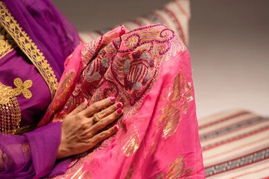 التزين بالحلي و المجوهرات الذهبية ،الاحتفال بليلة العمر ، العادات و التقاليد الخليجية في الزواج ،  احتفالات ومناسبات سعيدة، صورة مقربة لعروس عربية خليجية اماراتية ترتدي الزي الشعبي التقليدي تقوم باستعراض التحضيرات والتجهيزات للزفاف بإيماءات السعادة والفرح