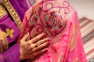Showing details of festive occasion attire, adorning with jewelry and gold ornaments, celebrating the night of a lifetime, Gulf customs and traditions in marriage, a close-up image of an Emirati Gulf Arab bride wearing traditional folk attire showcasing the preparations and arrangements for the wedding.