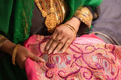 التزين بالحلي و المجوهرات الذهبية ،الاحتفال بليلة العمر ، العادات و التقاليد الخليجية في الزواج ،  احتفالات ومناسبات سعيدة، صورة مقربة لعروس عربية خليجية اماراتية ترتدي الزي الشعبي التقليدي تقوم باستعراض التحضيرات والتجهيزات للزفاف بإيماءات السعادة والفرح