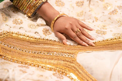 عرض تفاصيل ازياء المناسبات السعيدة ،التزين بالحلي و المجوهرات الذهبية ،الاحتفال بليلة العمر ، العادات و التقاليد الخليجية في الزواج ، صورة مقربة لعروس عربية خليجية اماراتية ترتدي الزي الشعبي التقليدي تقوم باستعراض التحضيرات والتجهيزات للزفاف