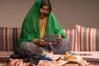 تصميم لحقيبة صغيرة باللون الاسود، مفهوم التزيين والإطلالة المتألقة، التزين بالحلي و المجوهرات الذهبية ، استخدام مساحيق التجميل لإبراز الجمال، عروس عربية خليجية اماراتية ترتدي الزي التقليدي الشعبي تقوم باستعراض التحضيرات والتجهيزات للزفاف، الاستعداد للاحتفال بليلة العمر