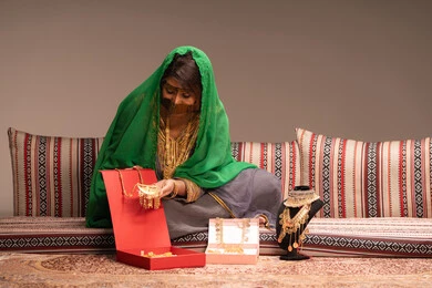 صيغة وشبكة زفاف ذهبية، مفهوم التزيين والإطلالة المتألقة، التزين بالحلي و المجوهرات الذهبية ، استخدام مساحيق التجميل لإبراز الجمال، عروس عربية خليجية اماراتية ترتدي الزي التقليدي الشعبي تقوم باستعراض التحضيرات والتجهيزات للزفاف،، الاستعداد للاحتفال بليلة العمر