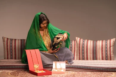 تفاصيل ونقوش الصيغة الذهبية، مفهوم التزيين والإطلالة المتألقة، التزين بالحلي و المجوهرات الذهبية ، استخدام مساحيق التجميل لإبراز الجمال، عروس عربية خليجية اماراتية ترتدي الزي التقليدي الشعبي تقوم باستعراض التحضيرات والتجهيزات للزفاف، الاستعداد للاحتفال بليلة العمر