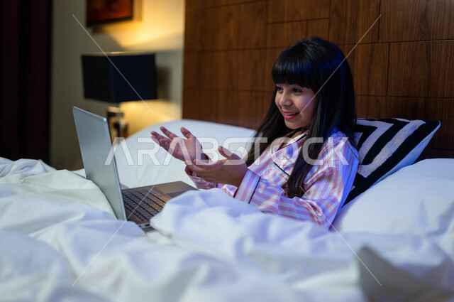 A Saudi Gulf Arab girl, having a video chat using a laptop computer, social communication and chatting, using modern technologies