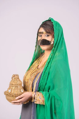 الاحتفال بليلة العمر، استعراض مراسم التحضيرات والتجهيزات للزفاف، مفهوم التزين والاطلالة المتألقة، الأفراح والمناسبات السعيدة، بورتريه لعروس عربية خليجية اماراتية ترتدي الثوب والبرقع والنشل تمسك بيدها مبخرة تقليدية ذهبية،التطيب بالبخور والعود، خلفية بيضاء