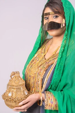 الاحتفال بليلة العمر، استعراض مراسم التحضيرات والتجهيزات للزفاف، مفهوم التزين والاطلالة المتألقة، الأفراح والمناسبات السعيدة، بورتريه لعروس عربية خليجية اماراتية ترتدي الثوب والبرقع والنشل تمسك بيدها مبخرة تقليدية ذهبية،التطيب بالبخور والعود، خلفية بيضاء